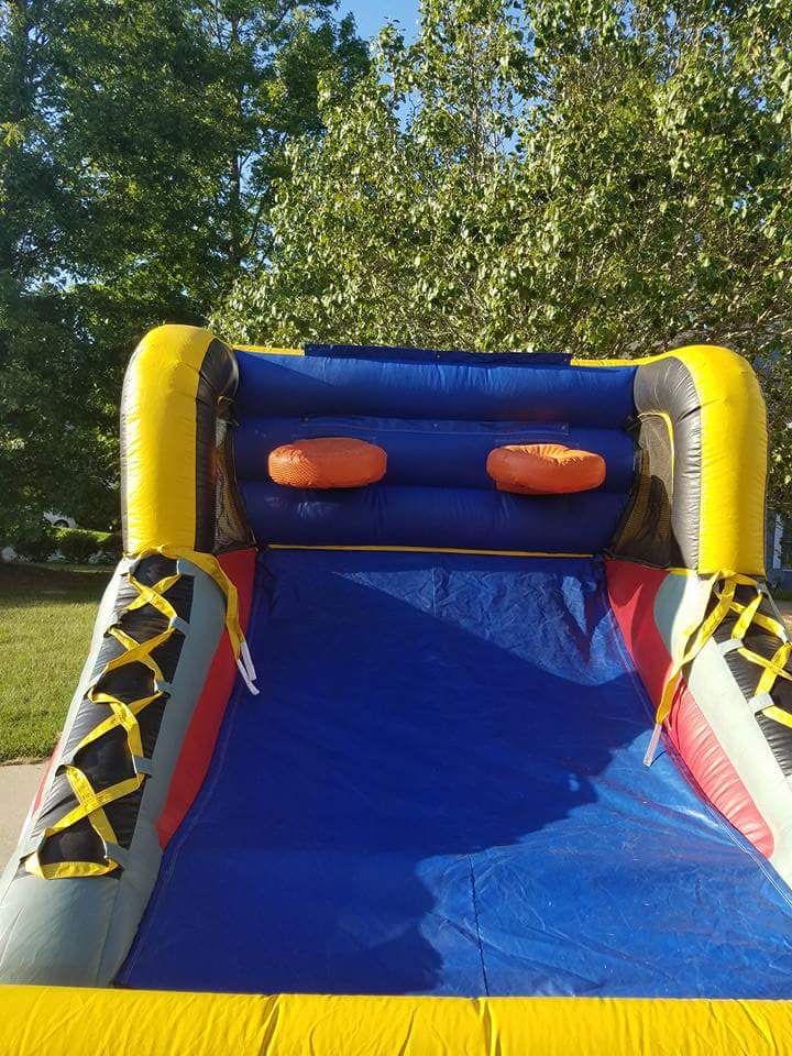 Bounce house and castle slide setup on grass